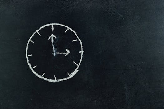 Chalk-drawn clock on a blackboard, symbolizing time and education concepts.